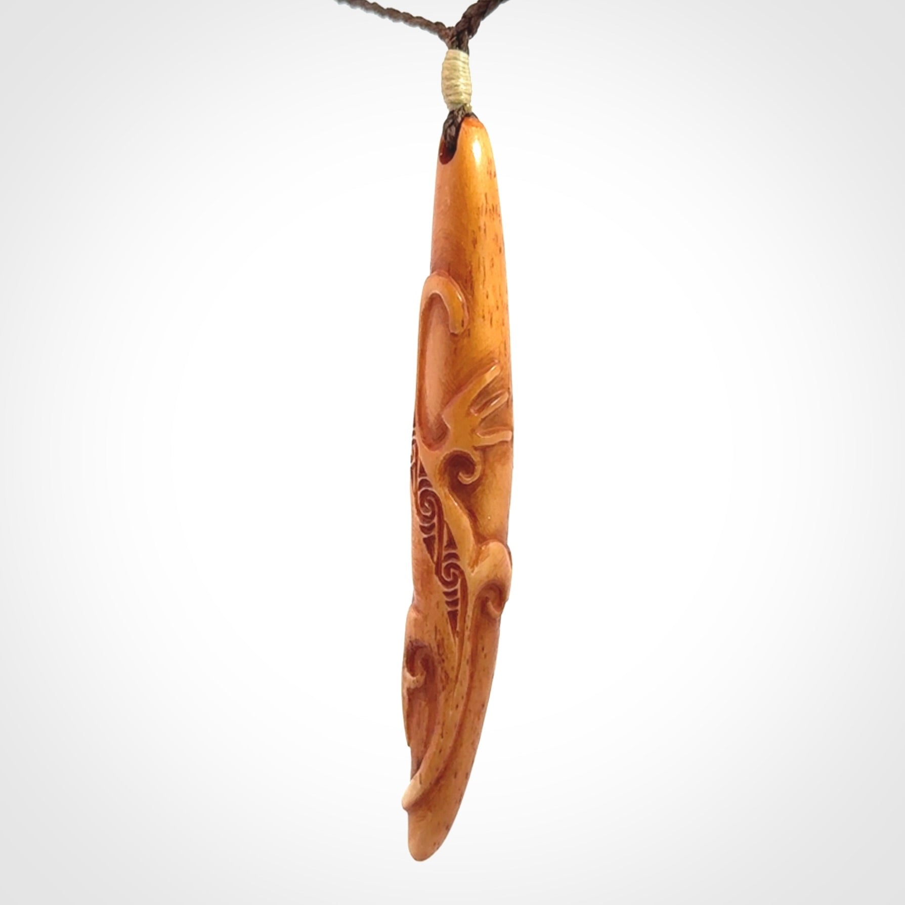 Bone carving of a lizard climbing. A three dimensional pendant carved in bone by Yuri Terenyi.