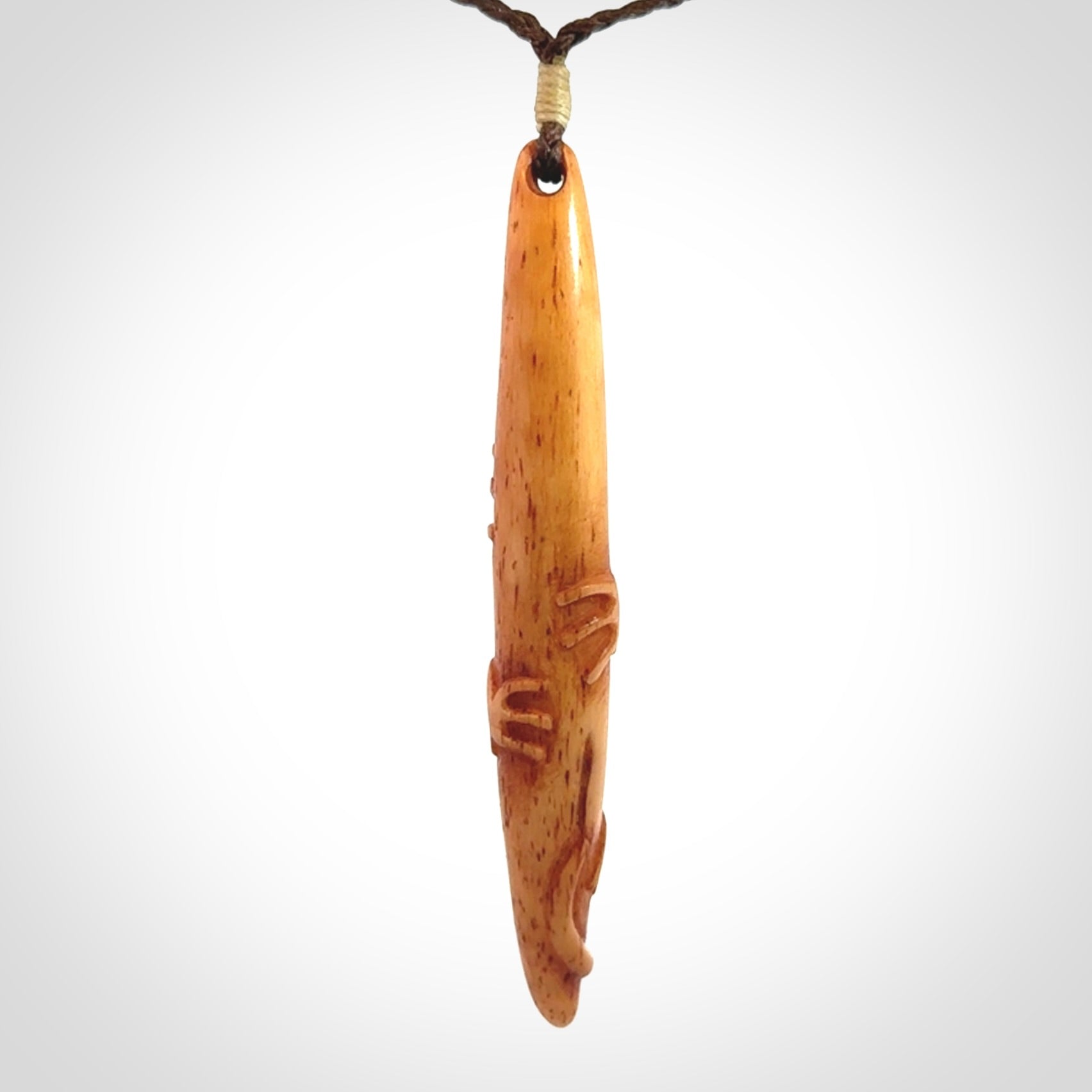 Bone carving of a lizard climbing. A three dimensional pendant carved in bone by Yuri Terenyi.