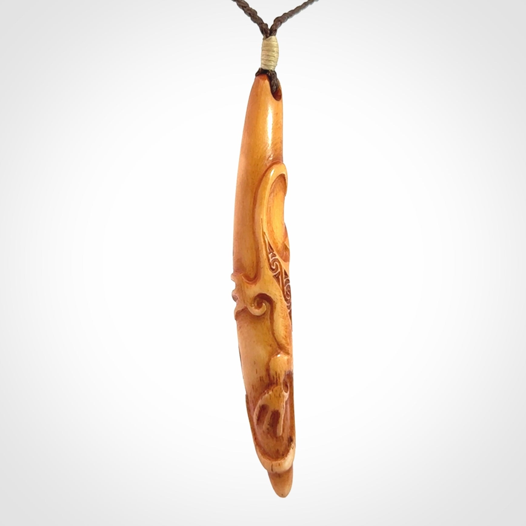 Bone carving of a lizard climbing. A three dimensional pendant carved in bone by Yuri Terenyi.