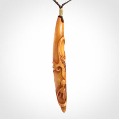 Bone carving of a lizard climbing. A three dimensional pendant carved in bone by Yuri Terenyi.