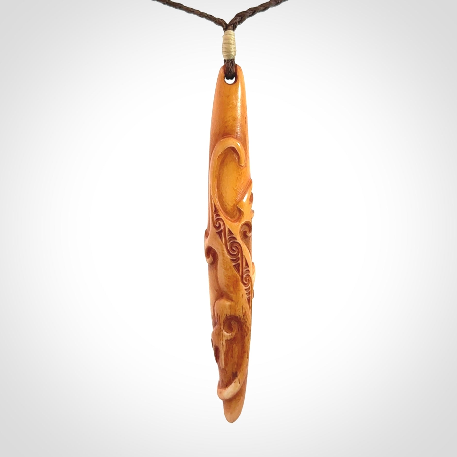 Bone carving of a lizard climbing. A three dimensional pendant carved in bone by Yuri Terenyi.
