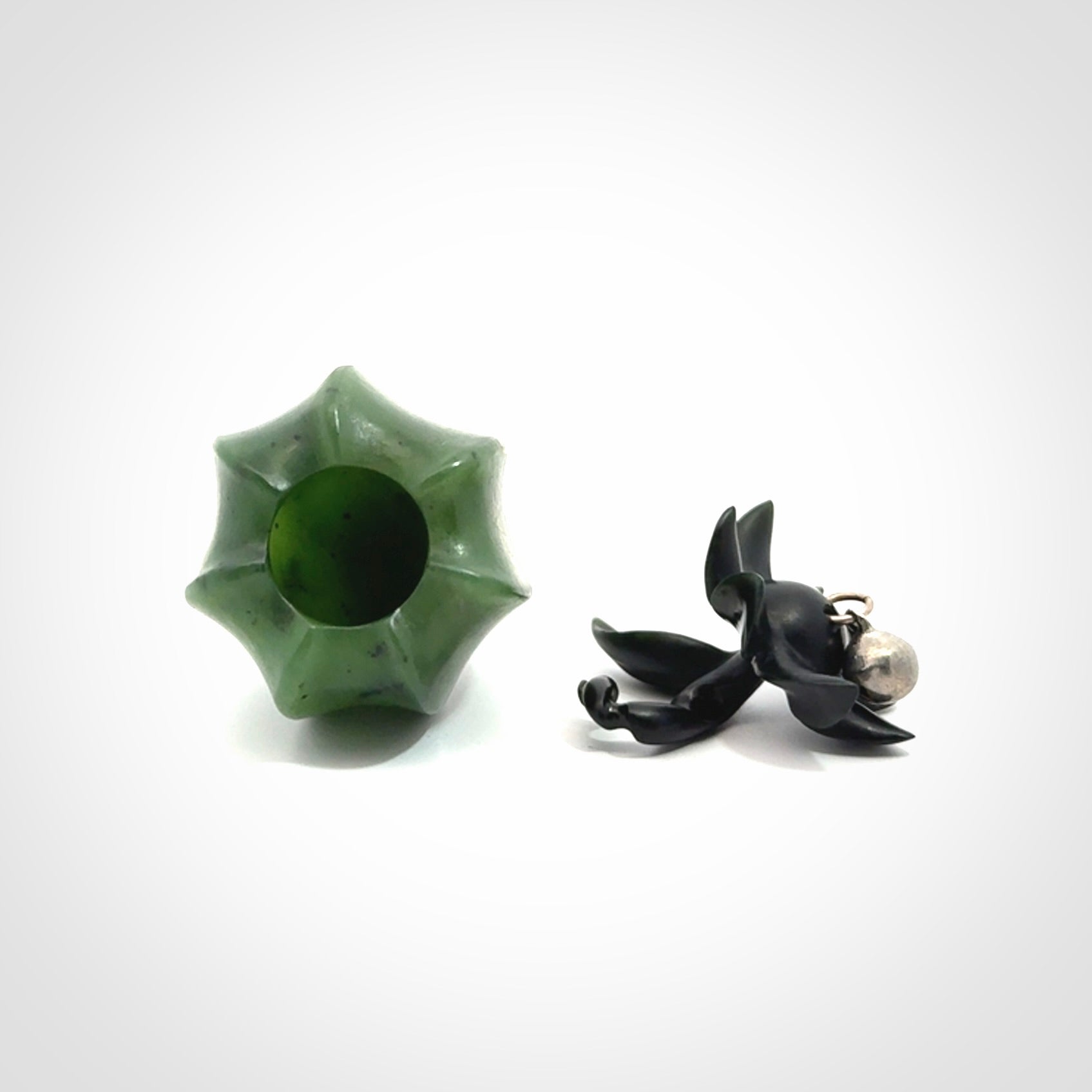 Hand carved Gooseberry sculpture crafted in Black Jade, British Columbian Jade with Basalt stone stand. One only Gooseberry sculpture with lid that encloses a bell.