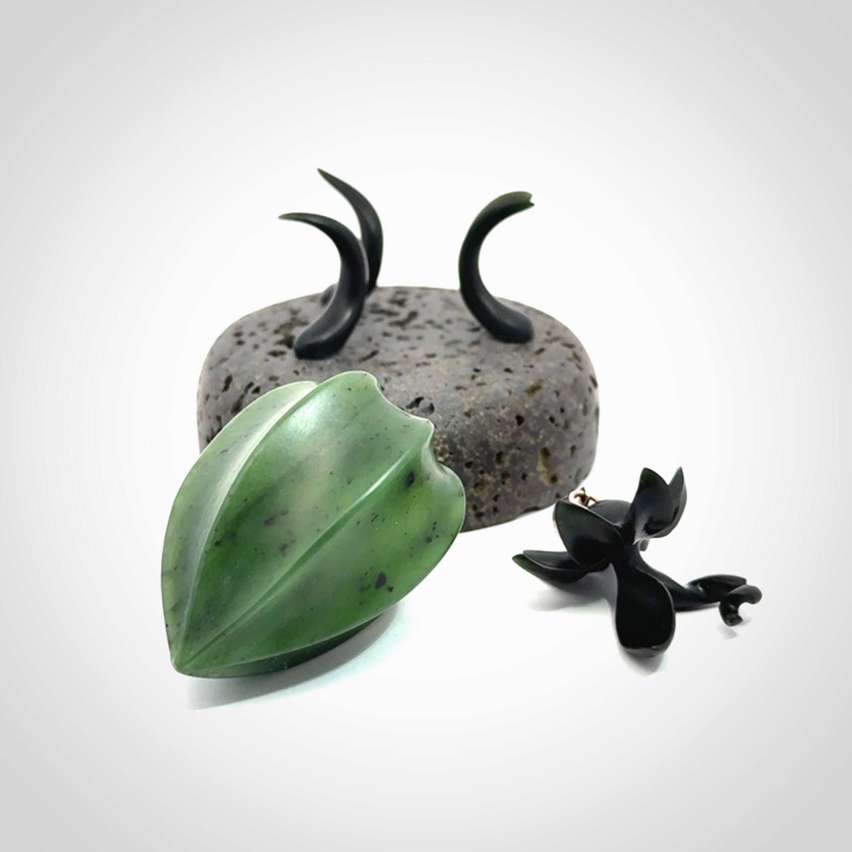 Hand carved Gooseberry sculpture crafted in Black Jade, British Columbian Jade with Basalt stone stand. One only Gooseberry sculpture with lid that encloses a bell.