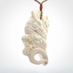 This is a hand carved bone baby dragon pendant. It is made from bone and has an adjustable tan coloured cord. This is a large sized necklace and is a very unique, one only, pendant that is a piece for art lovers.