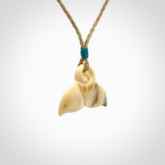 This photo shows a small whaletail pendant that we have carved from a light honey coloured piece of Woolly Mammoth tusk. It is suspended on a tan cord that is length adjustable.