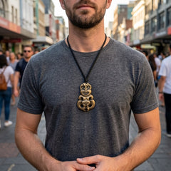 Man wearing bronze tiki pendant