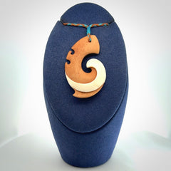 A wonderful two-tone bone koru pendant
