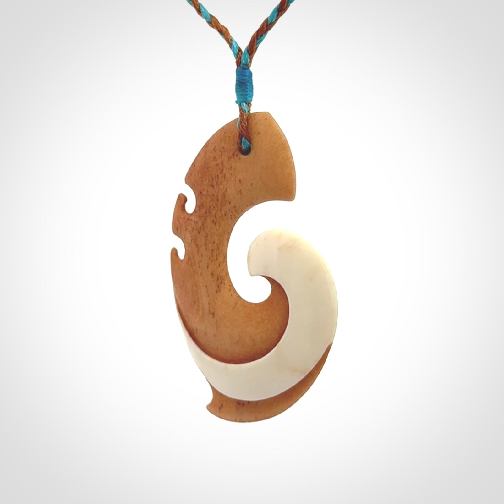 A wonderful two-tone bone koru pendant