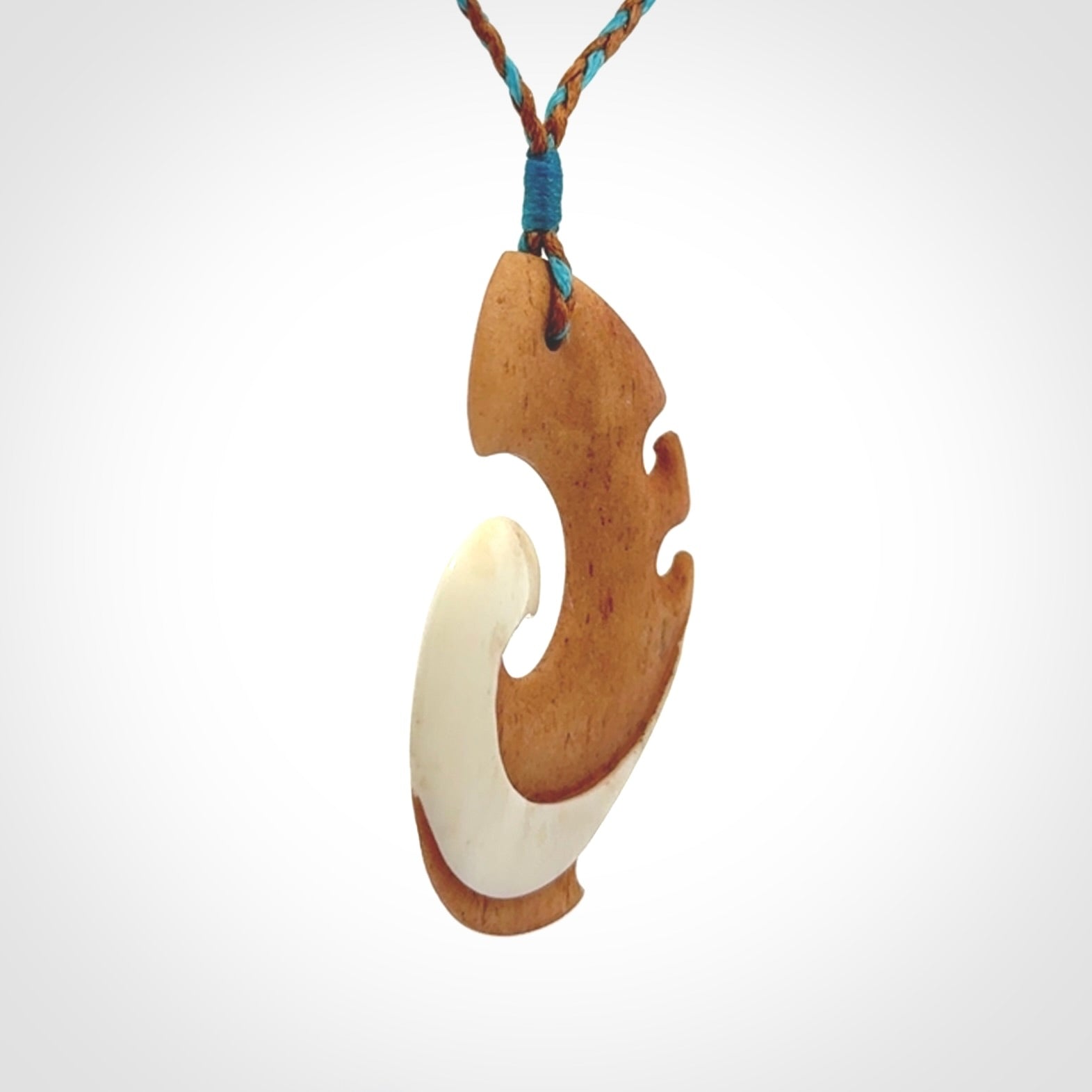 A wonderful two-tone bone koru pendant