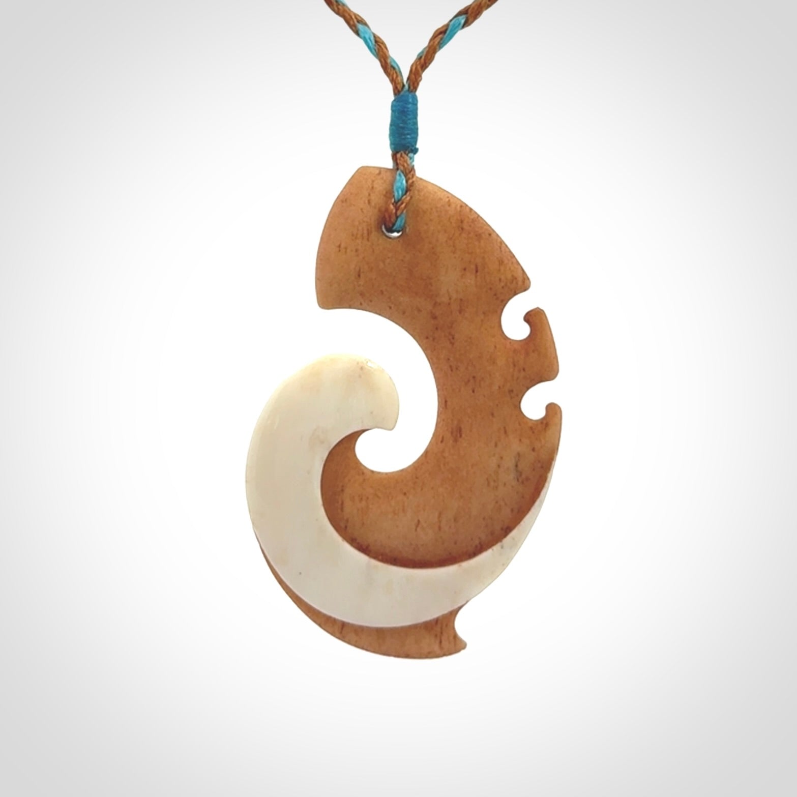 A wonderful two-tone bone koru pendant