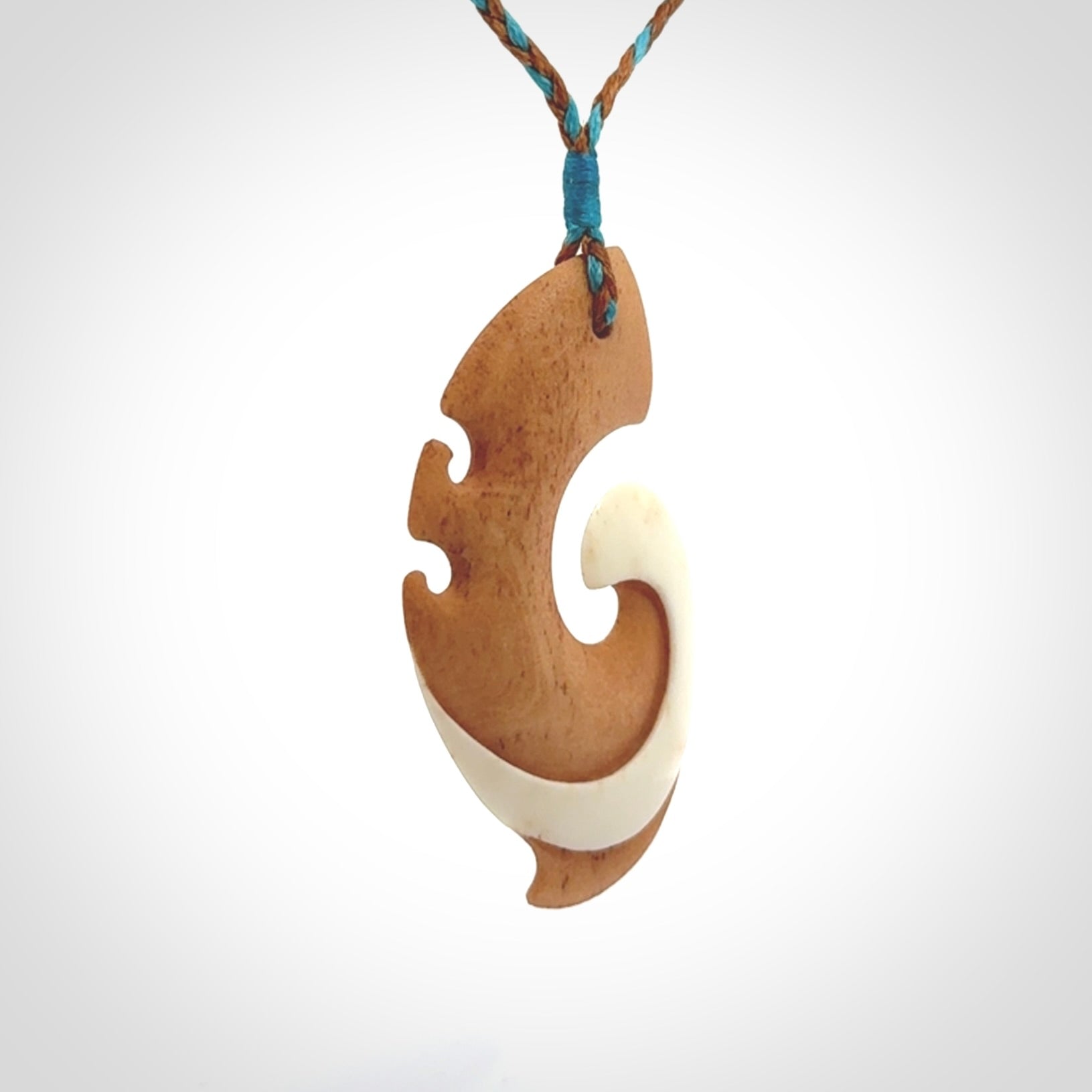 A wonderful two-tone bone koru pendant