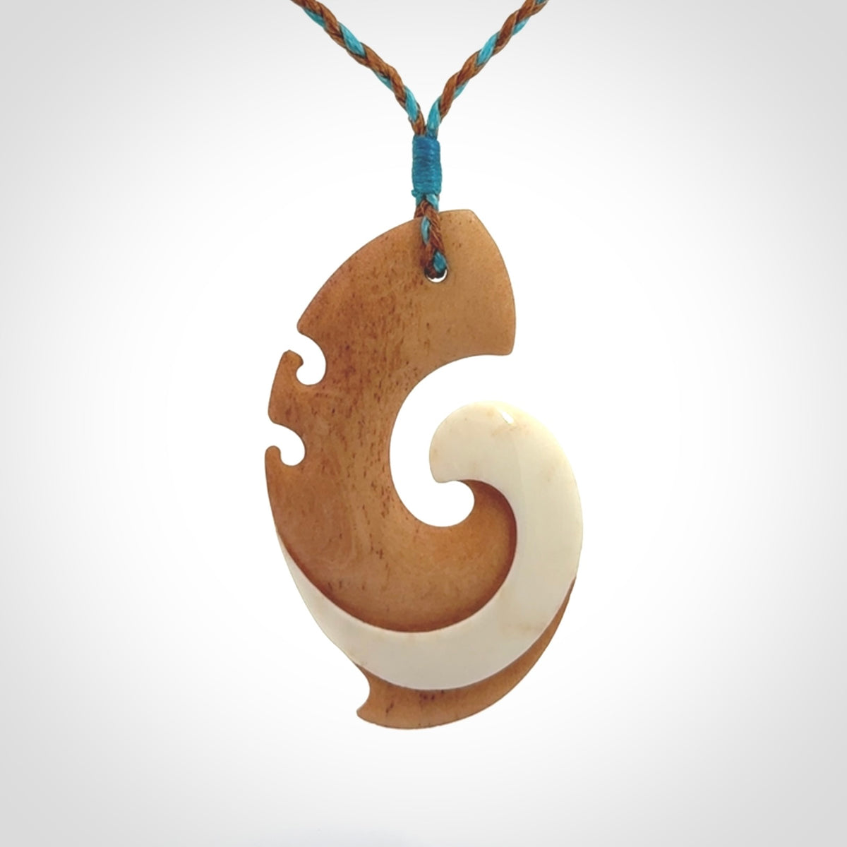 A wonderful two-tone bone koru pendant