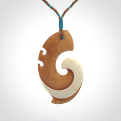 A wonderful two-tone bone koru pendant