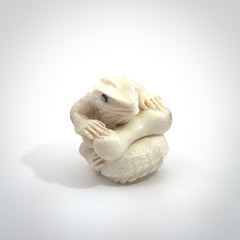 Hand carved incredible tuatara with dinosaur bone carving. A stunning work of art, beautifully replicating a tuatara holding a dinosaur bone. A one off collectors item that has been hand crafted to be worn or displayed.