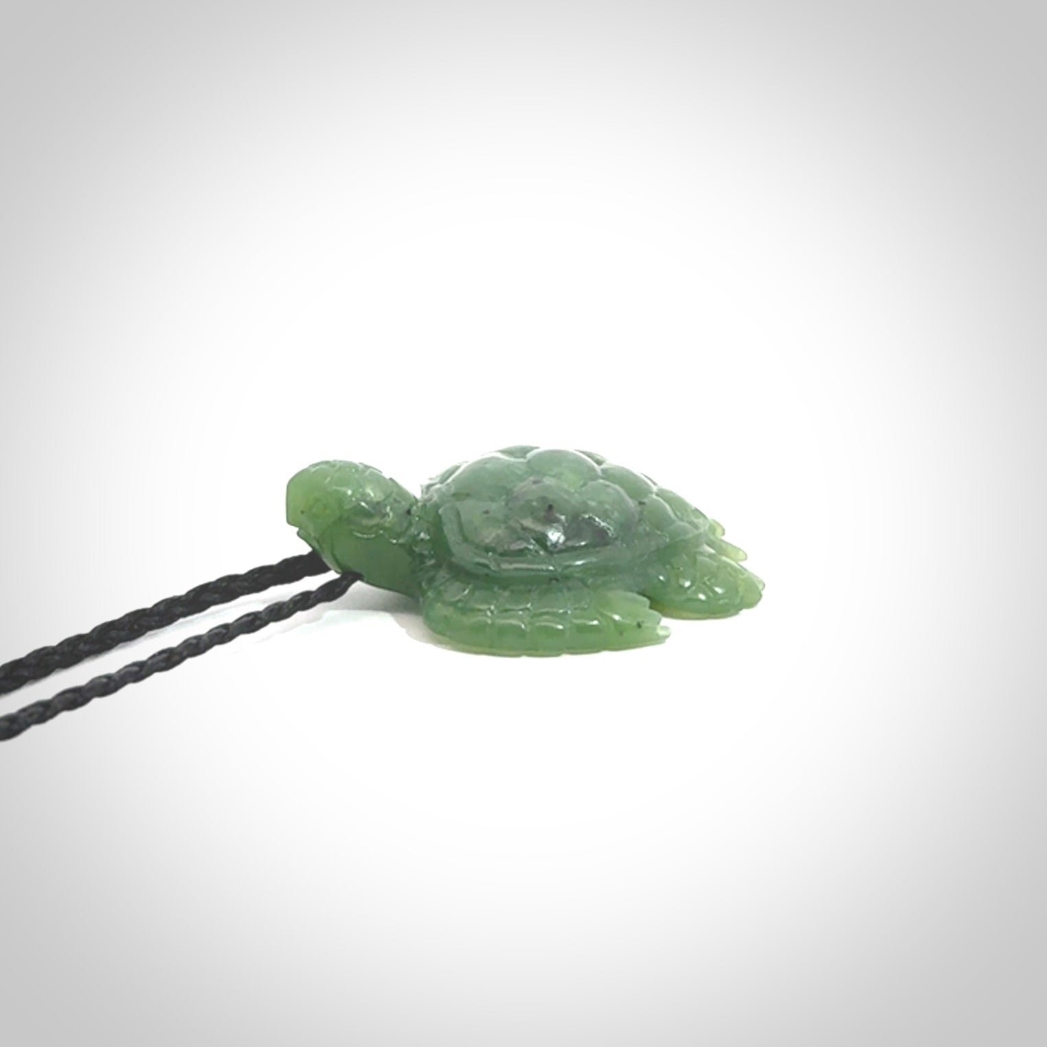 British Columbian jade turtle pendant. Hand carved jade turtle pendant, made by NZ Pacific for sale online. Unique handmade jewellery. Provided with an adjustable cord and packaged in a woven kete pouch.