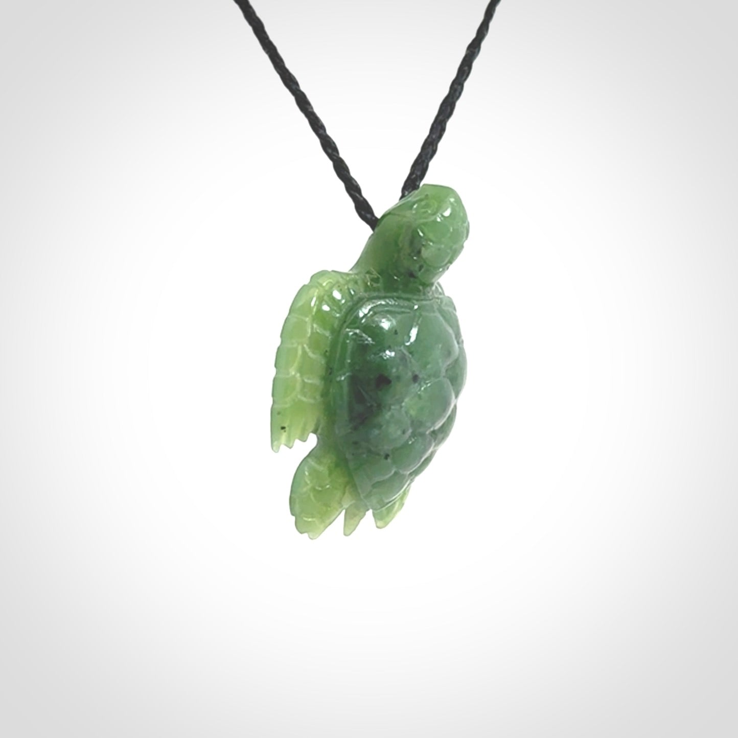 British Columbian jade turtle pendant. Hand carved jade turtle pendant, made by NZ Pacific for sale online. Unique handmade jewellery. Provided with an adjustable cord and packaged in a woven kete pouch.