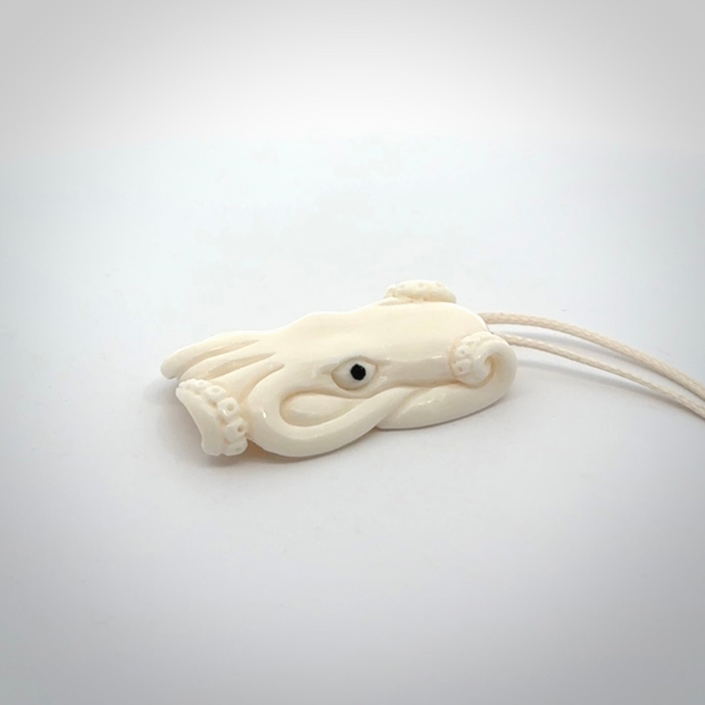This is a beautiful little hand carved octopus pendant. It is a very cute little pendant that we have carved in natural, untreated bone. We provide these with meringue adjustable cords and shipping is included worldwide.