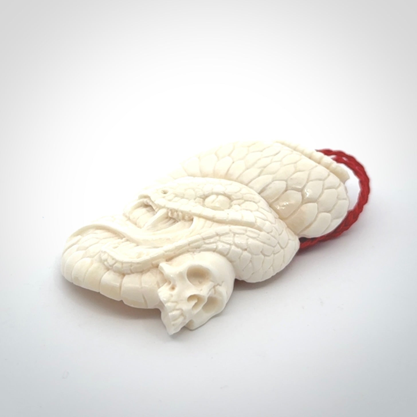 Hand carved bone snake skull pendant. Hand carved by NZ Pacific. Free postage worldwide. Hand made snake with skull necklace from bone. Snake skull necklace for men and women.