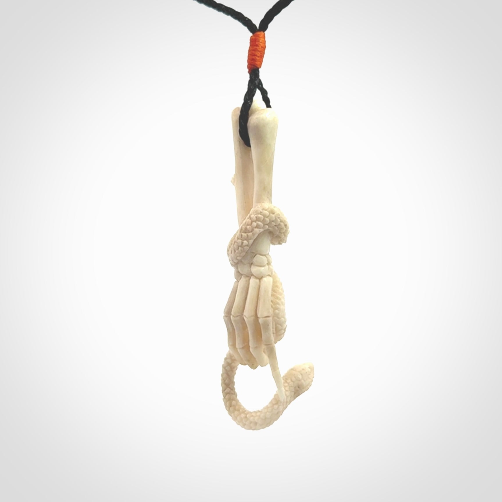 Hand carved deer antler skeleton hand with snake pendant. Hand carved by NZ Pacific. Free postage worldwide. Hand made skeleton hand with snake necklace from deer antler. Skeleton hand with snake necklace for men and women.