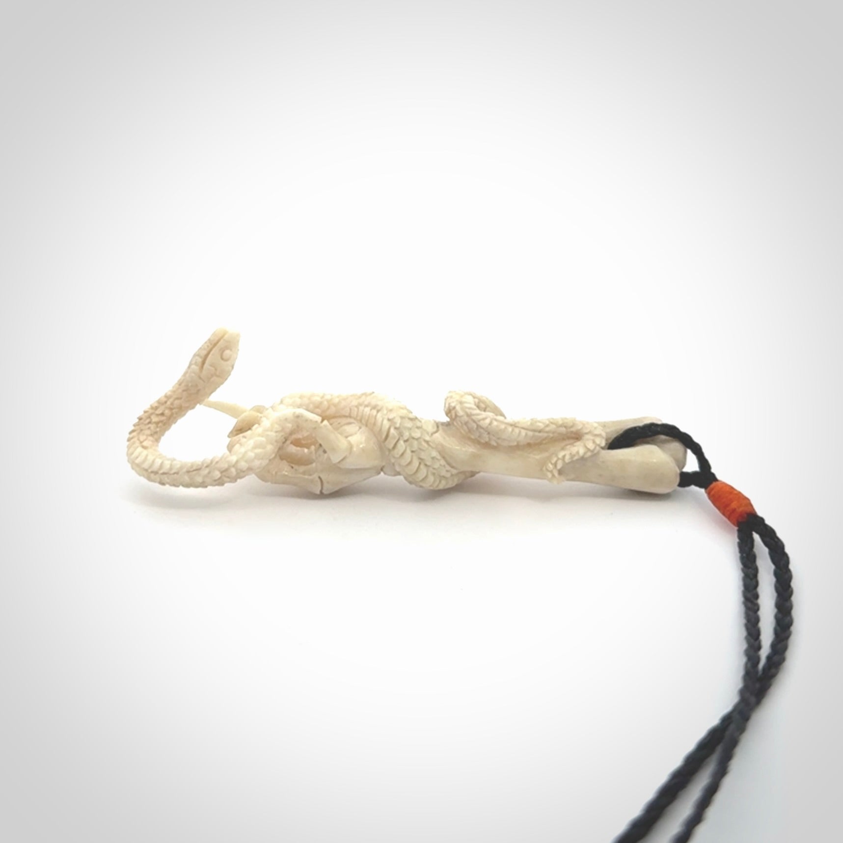 Hand carved deer antler skeleton hand with snake pendant. Hand carved by NZ Pacific. Free postage worldwide. Hand made skeleton hand with snake necklace from deer antler. Skeleton hand with snake necklace for men and women.