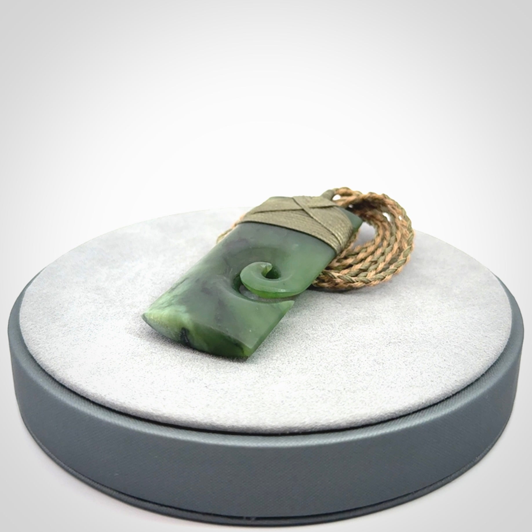 New Zealand jade toki koru pendant. Hand carved in New Zealand. Hand made New Zealand Jade jewellery. Provided with an adjustable cord and packaged in a woven kete pouch.