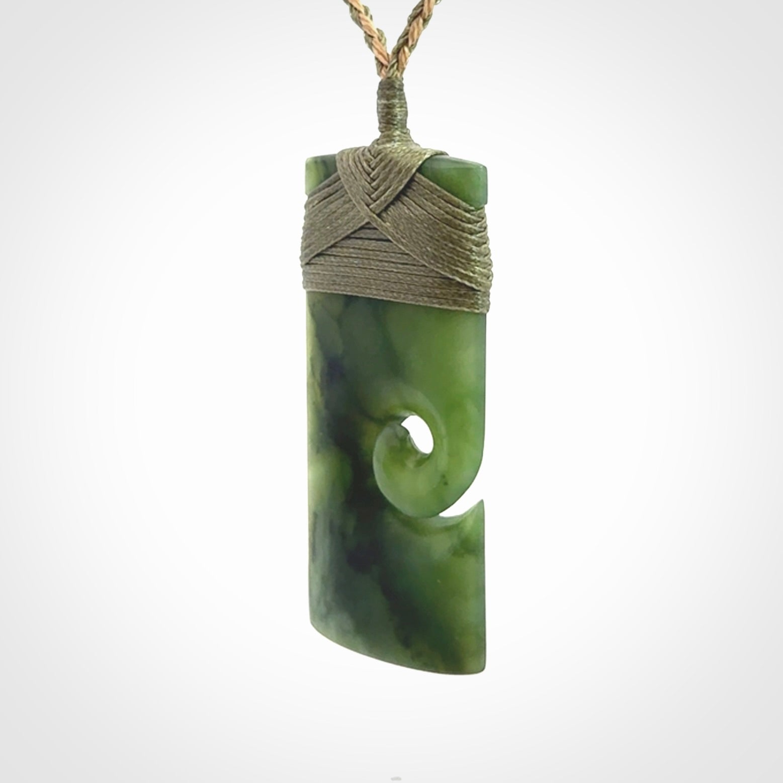 New Zealand jade toki koru pendant. Hand carved in New Zealand. Hand made New Zealand Jade jewellery. Provided with an adjustable cord and packaged in a woven kete pouch.