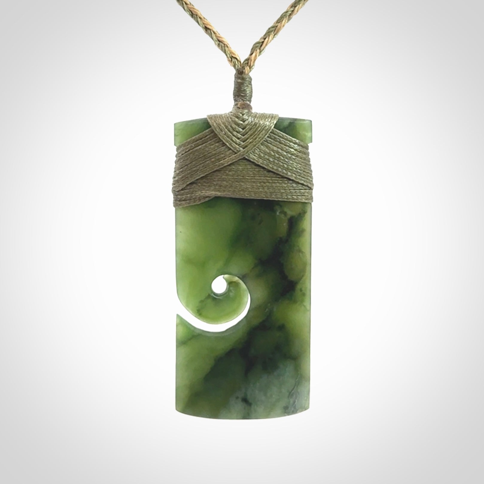 New Zealand jade toki koru pendant. Hand carved in New Zealand. Hand made New Zealand Jade jewellery. Provided with an adjustable cord and packaged in a woven kete pouch.