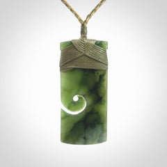 New Zealand jade toki koru pendant. Hand carved in New Zealand. Hand made New Zealand Jade jewellery. Provided with an adjustable cord and packaged in a woven kete pouch.