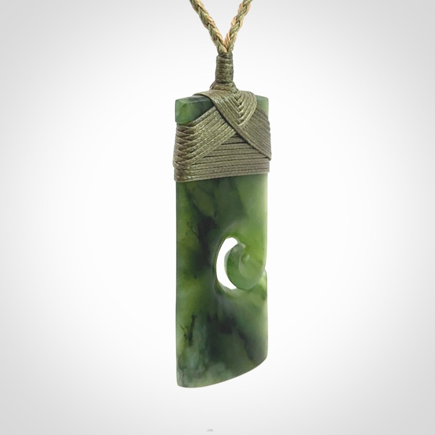 New Zealand jade toki koru pendant. Hand carved in New Zealand. Hand made New Zealand Jade jewellery. Provided with an adjustable cord and packaged in a woven kete pouch.