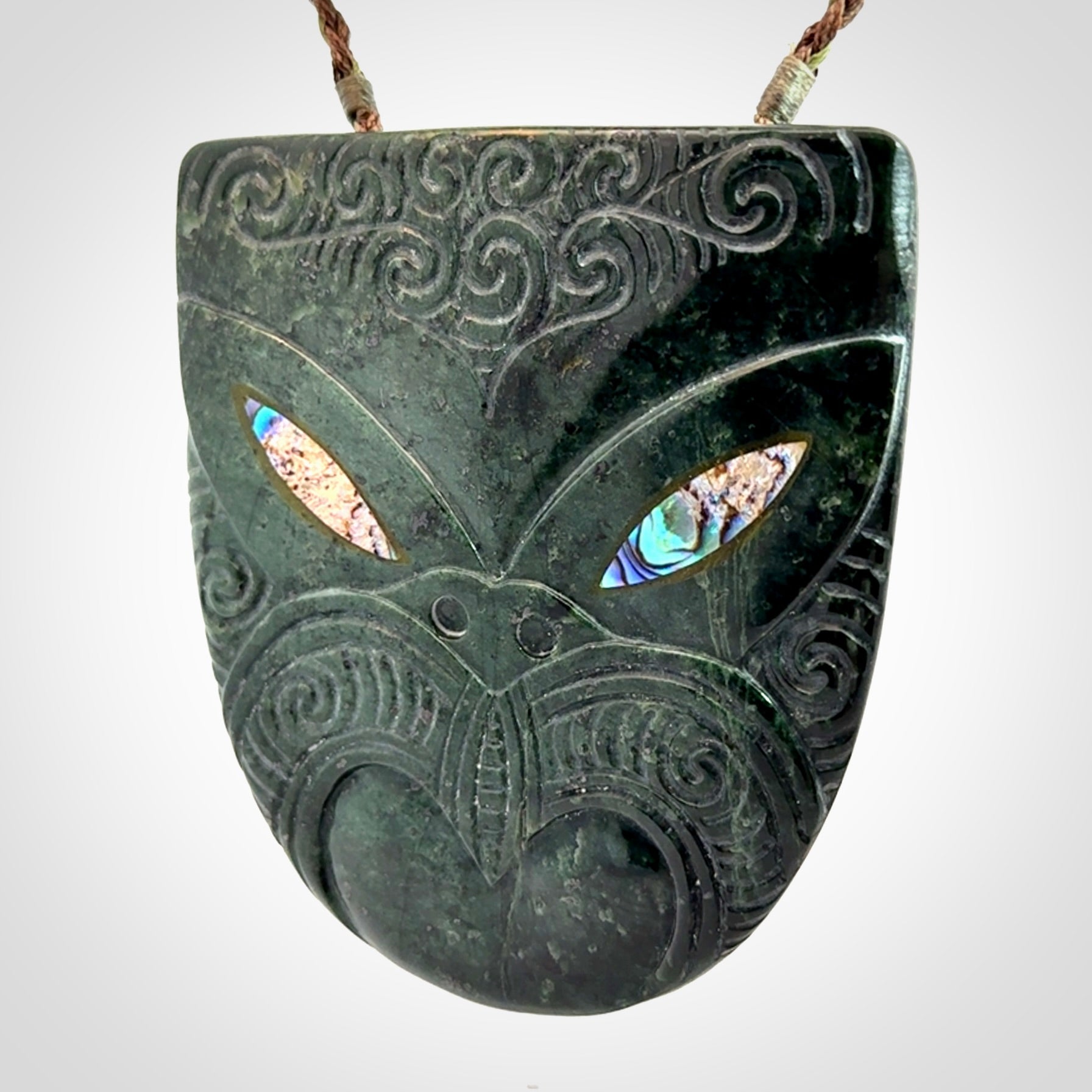 Hand carved New Zealand Jade wheku pendant with paua shell eyes