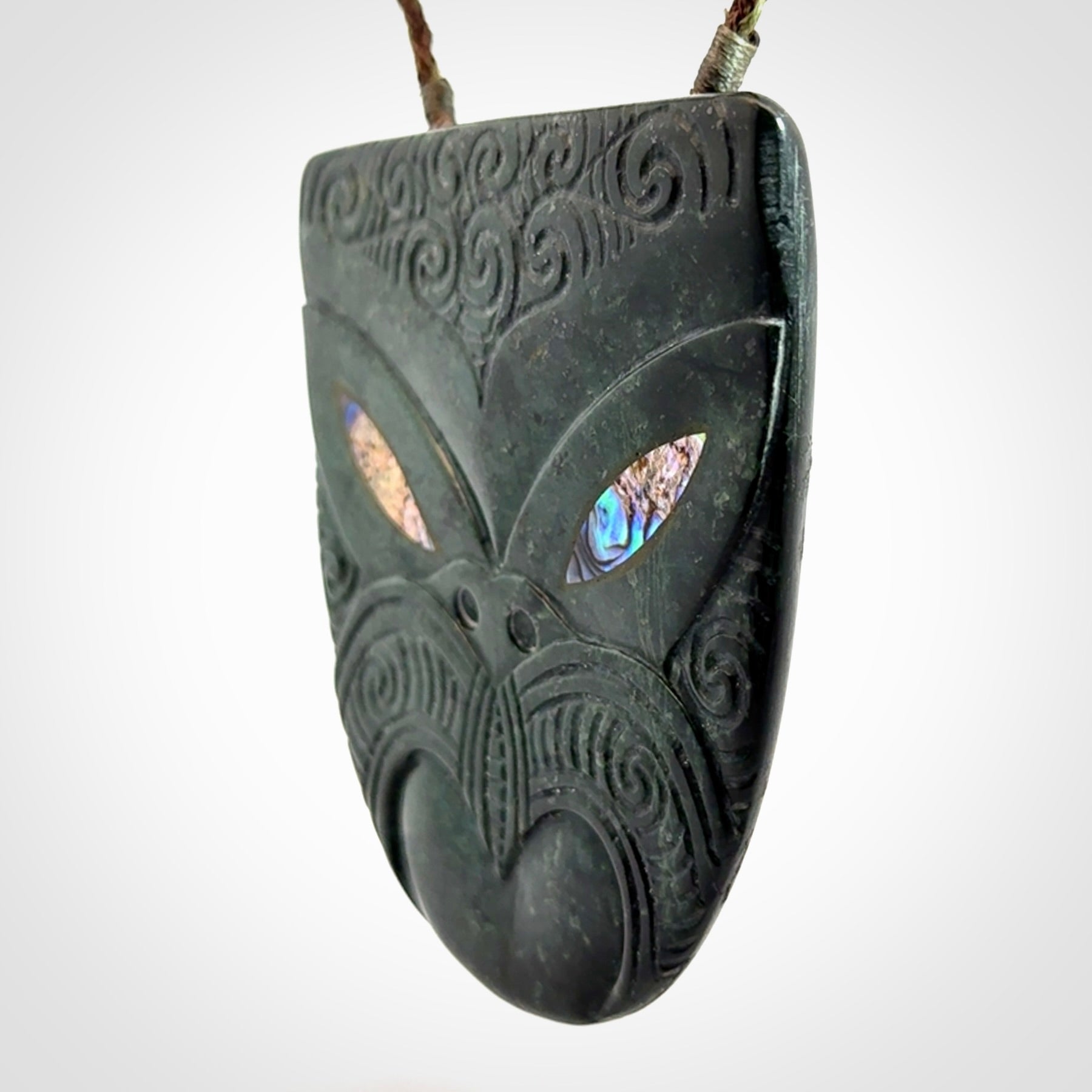 Hand carved New Zealand Jade wheku pendant with paua shell eyes