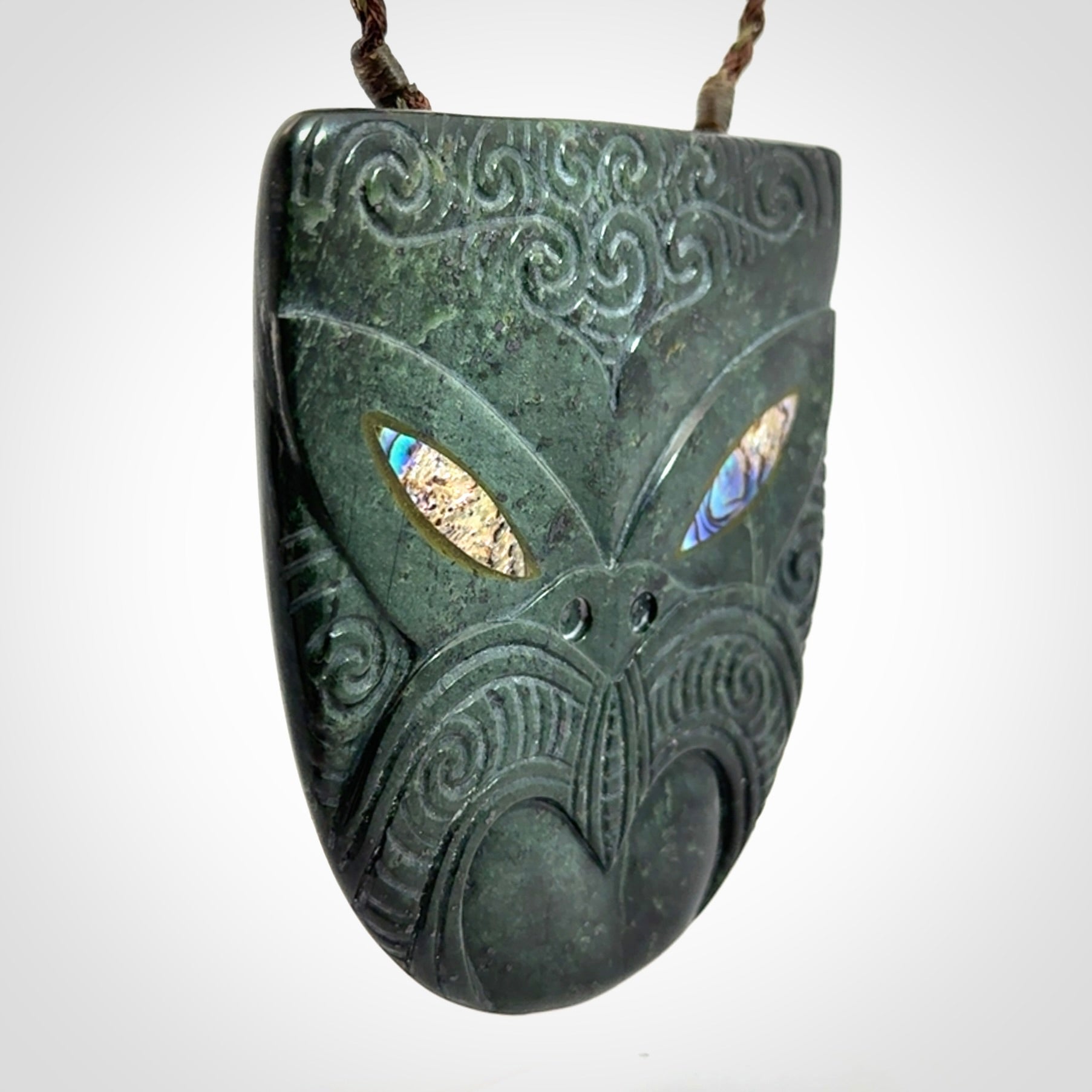 Hand carved New Zealand Jade wheku pendant with paua shell eyes