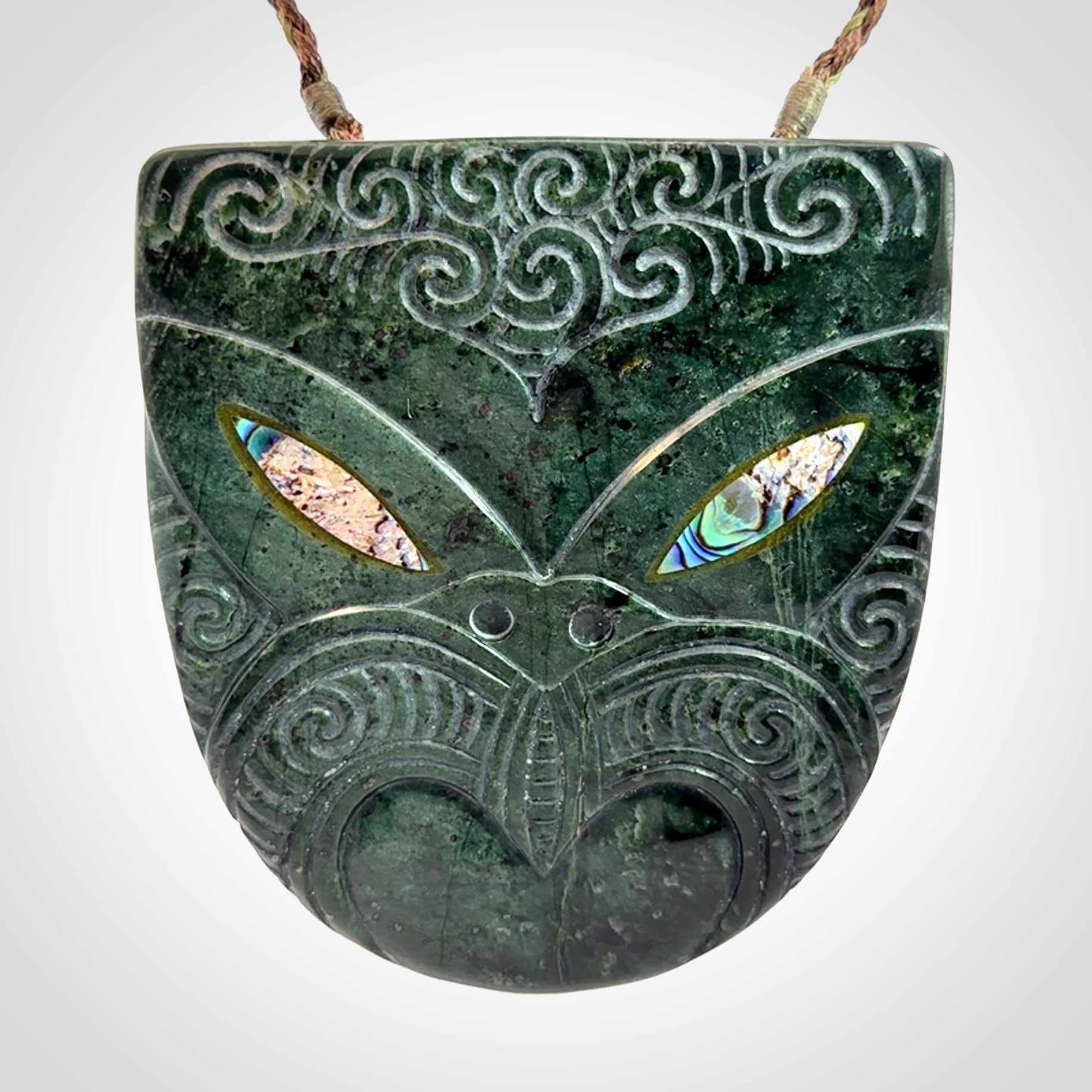 Hand carved New Zealand Jade wheku pendant with paua shell eyes