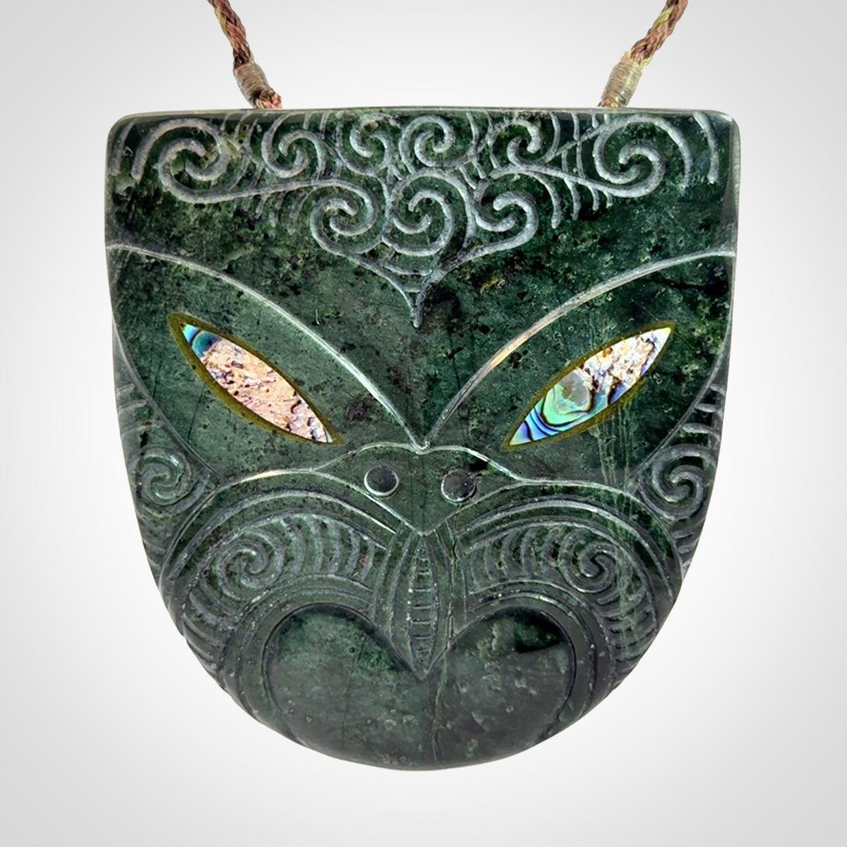Hand carved New Zealand Jade wheku pendant with paua shell eyes
