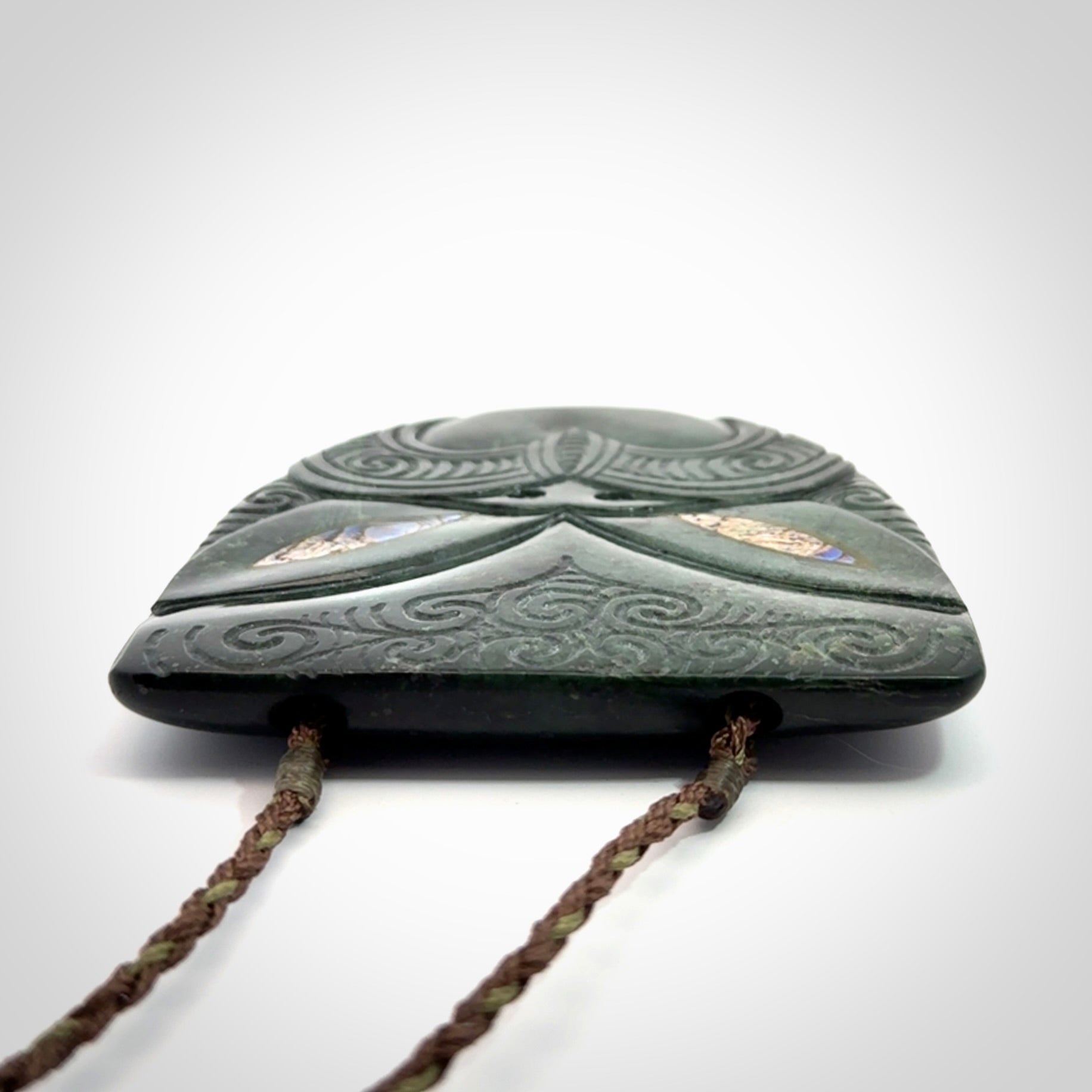 Hand carved New Zealand Jade wheku pendant with paua shell eyes
