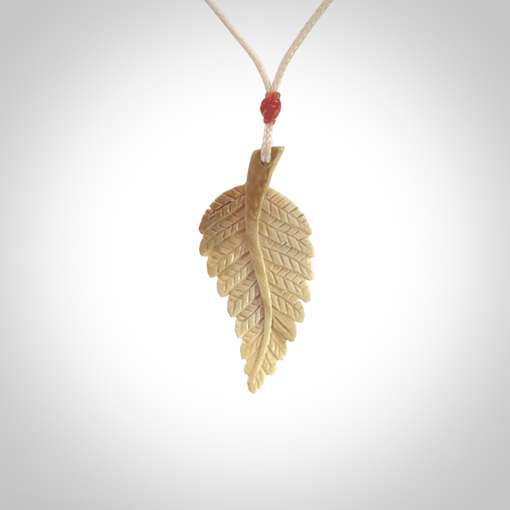 Hand carved woolly mammoth tusk fern pendant. Made in New Zealand. Unique hand made gifts from NZ Pacific. Hand carved fern necklace from ancient woolly mammoth tusk.