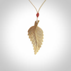 Hand carved woolly mammoth tusk fern pendant. Made in New Zealand. Unique hand made gifts from NZ Pacific. Hand carved fern necklace from ancient woolly mammoth tusk.