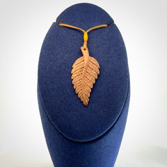 Hand carved woolly mammoth tusk fern pendant. Made in New Zealand. Unique hand made gifts from NZ Pacific. Hand carved fern necklace from ancient woolly mammoth tusk.
