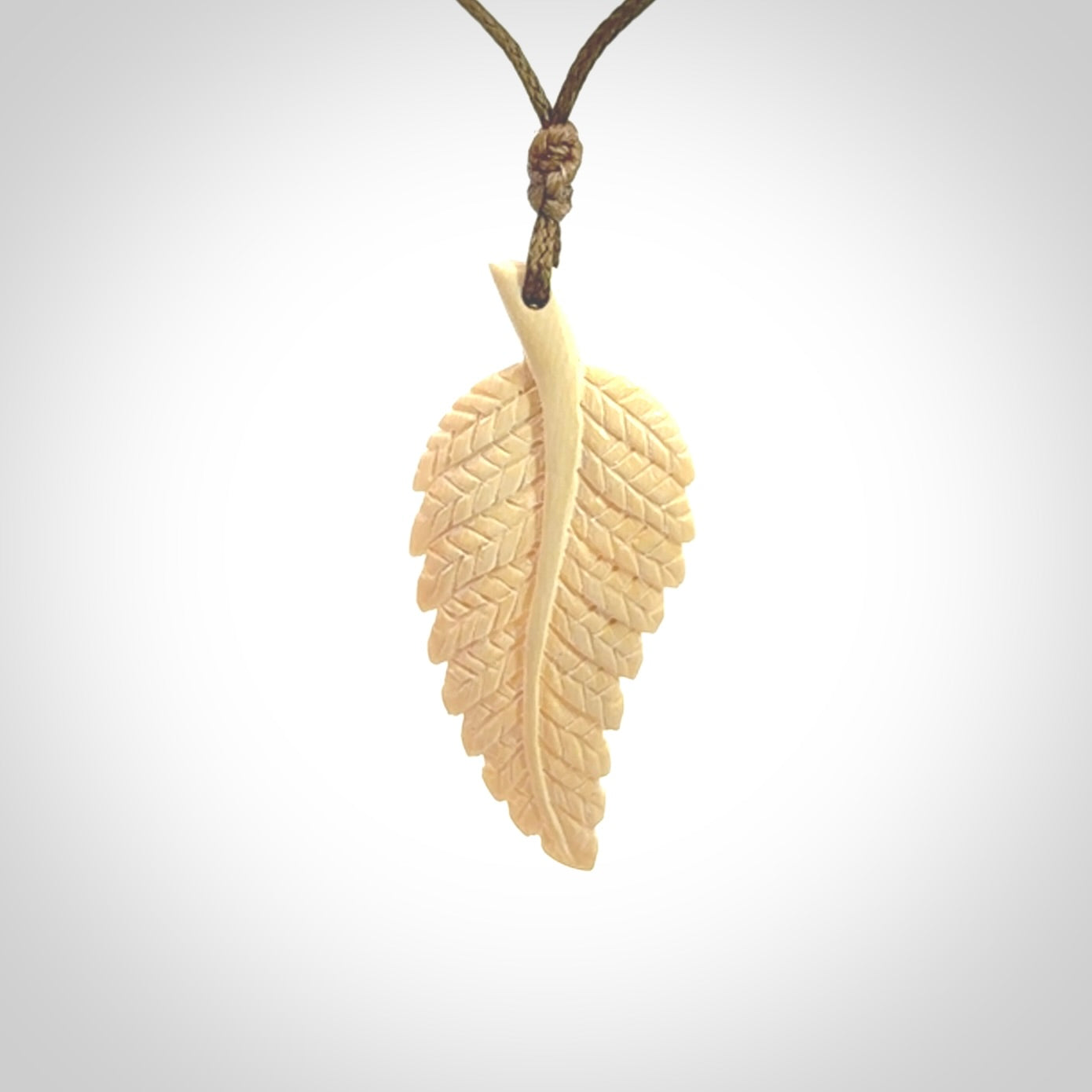 Hand carved woolly mammoth tusk fern pendant. Made in New Zealand. Unique hand made gifts from NZ Pacific. Hand carved fern necklace from ancient woolly mammoth tusk.