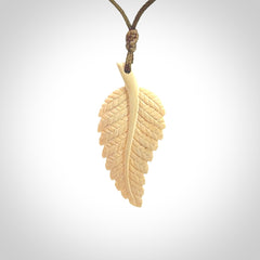 Hand carved woolly mammoth tusk fern pendant. Made in New Zealand. Unique hand made gifts from NZ Pacific. Hand carved fern necklace from ancient woolly mammoth tusk.