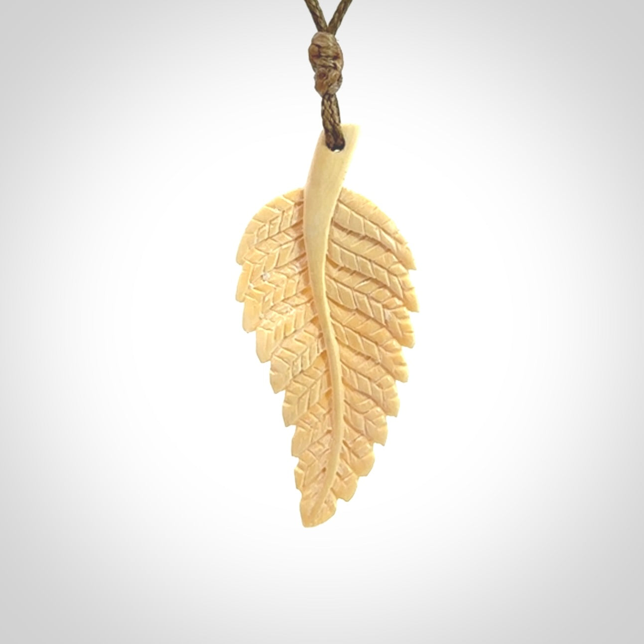 Hand carved woolly mammoth tusk fern pendant. Made in New Zealand. Unique hand made gifts from NZ Pacific. Hand carved fern necklace from ancient woolly mammoth tusk.