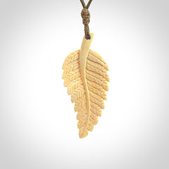 Hand carved woolly mammoth tusk fern pendant. Made in New Zealand. Unique hand made gifts from NZ Pacific. Hand carved fern necklace from ancient woolly mammoth tusk.