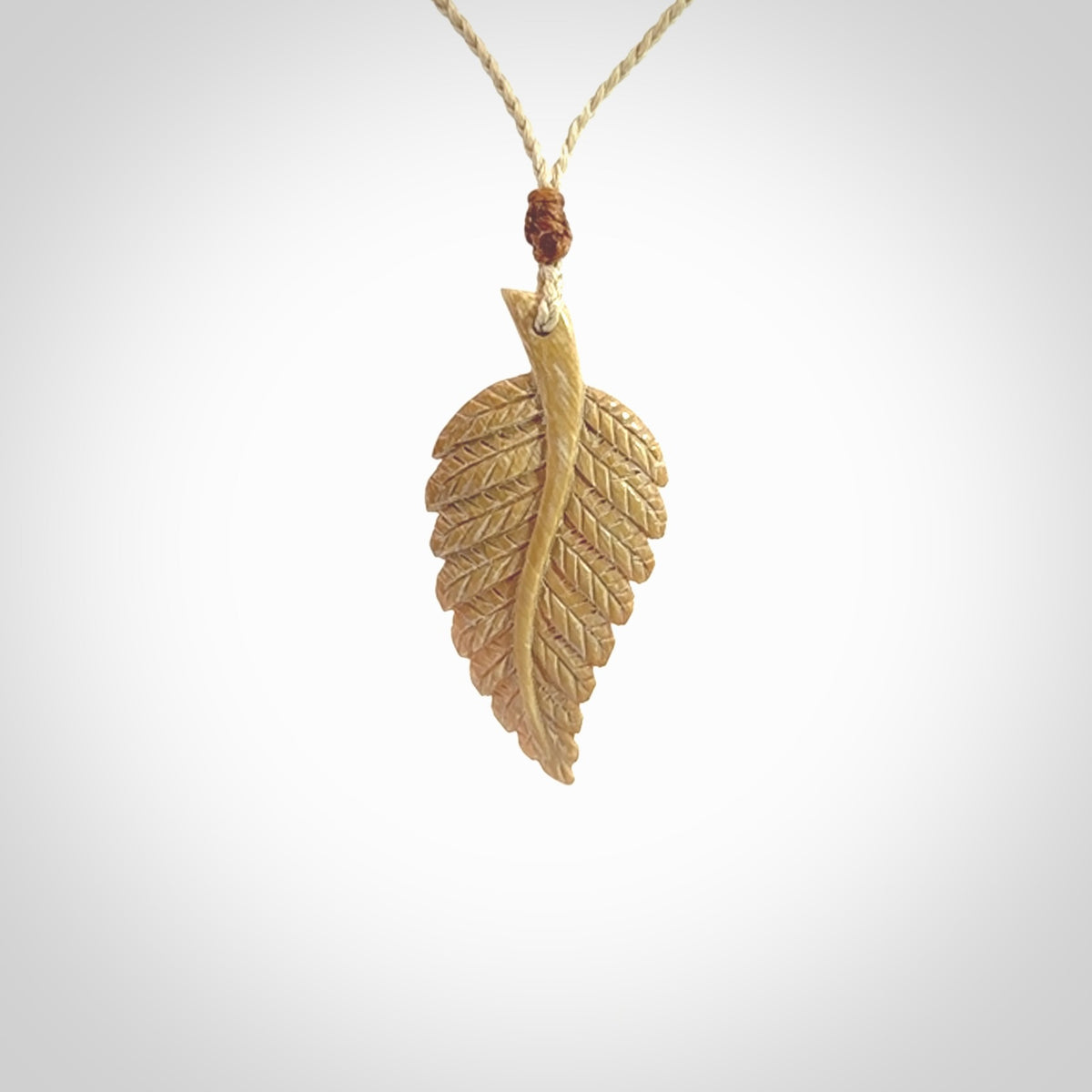 Hand carved woolly mammoth tusk fern pendant. Made in New Zealand. Unique hand made gifts from NZ Pacific. Hand carved fern necklace from ancient woolly mammoth tusk.