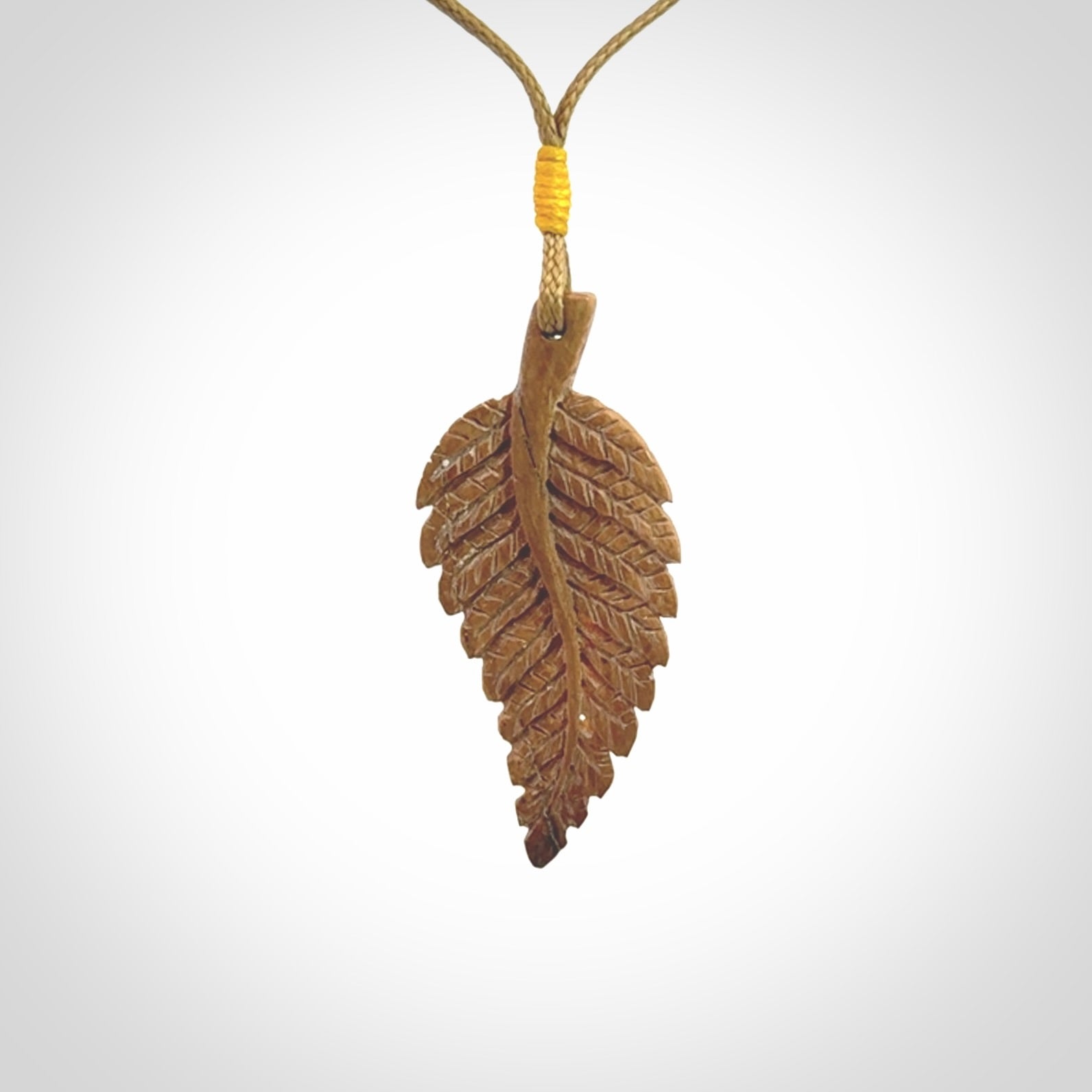 Hand carved woolly mammoth tusk fern pendant. Made in New Zealand. Unique hand made gifts from NZ Pacific. Hand carved fern necklace from ancient woolly mammoth tusk.