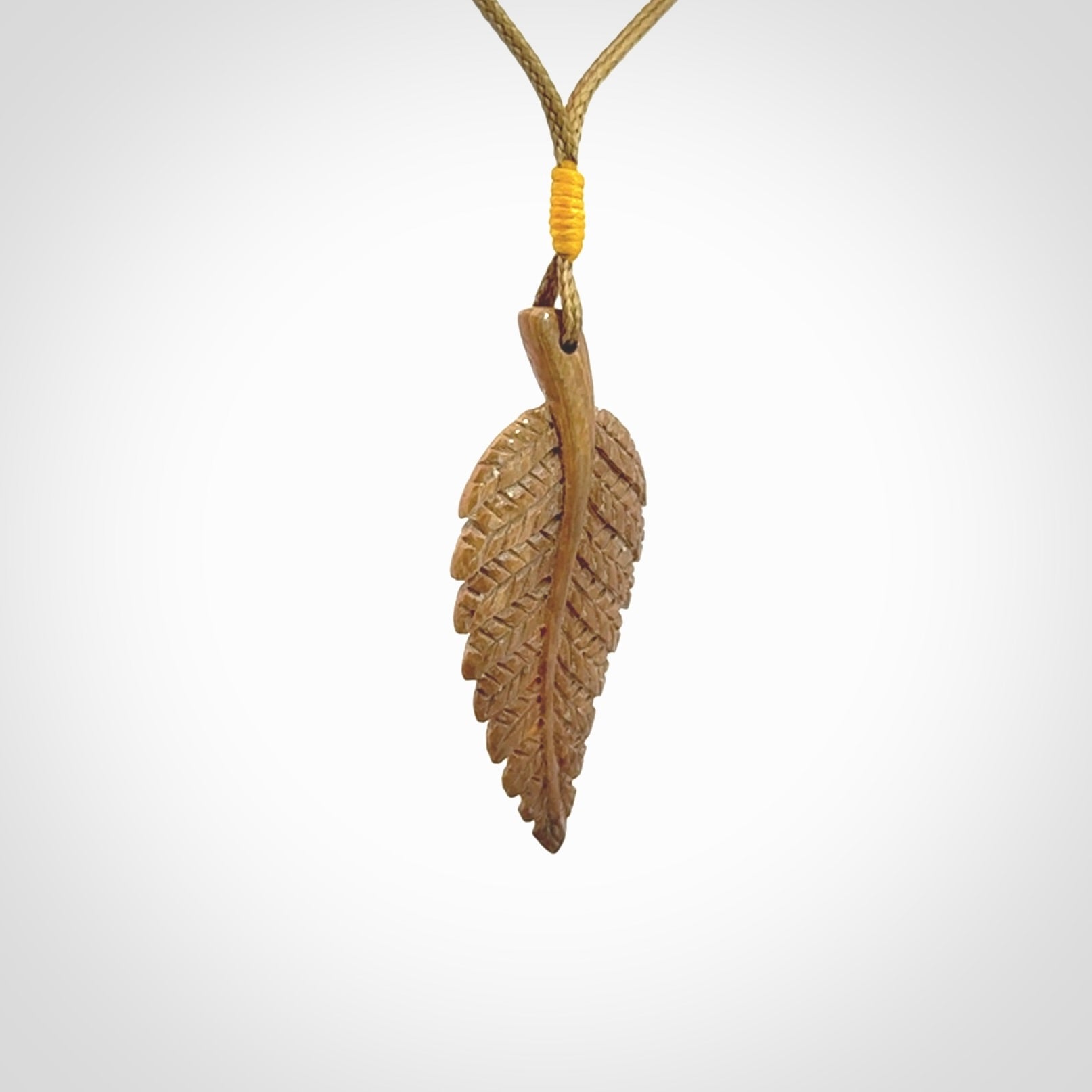Hand carved woolly mammoth tusk fern pendant. Made in New Zealand. Unique hand made gifts from NZ Pacific. Hand carved fern necklace from ancient woolly mammoth tusk.
