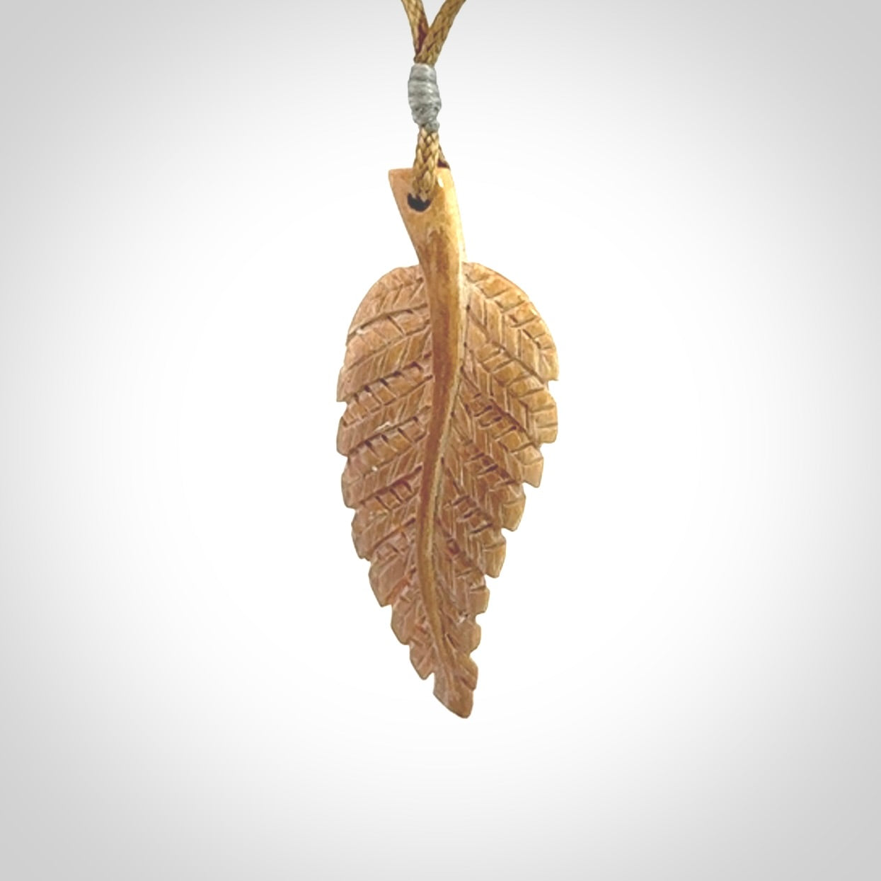 Hand carved woolly mammoth tusk fern pendant. Made in New Zealand. Unique hand made gifts from NZ Pacific. Hand carved fern necklace from ancient woolly mammoth tusk.