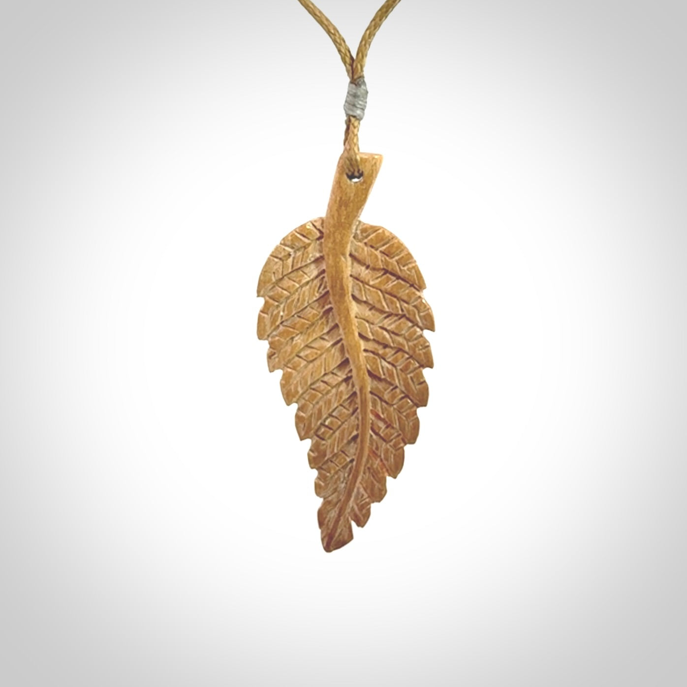 Hand carved woolly mammoth tusk fern pendant. Made in New Zealand. Unique hand made gifts from NZ Pacific. Hand carved fern necklace from ancient woolly mammoth tusk.