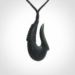 This photo shows a greenstone hook, or matau, pendant. It is a beautiful deep green jade. The cord is plaited and the length can be adjusted.