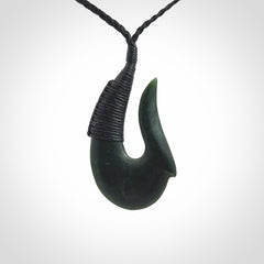 This photo shows a greenstone hook, or matau, pendant. It is a beautiful deep green jade. The cord is plaited and the length can be adjusted.