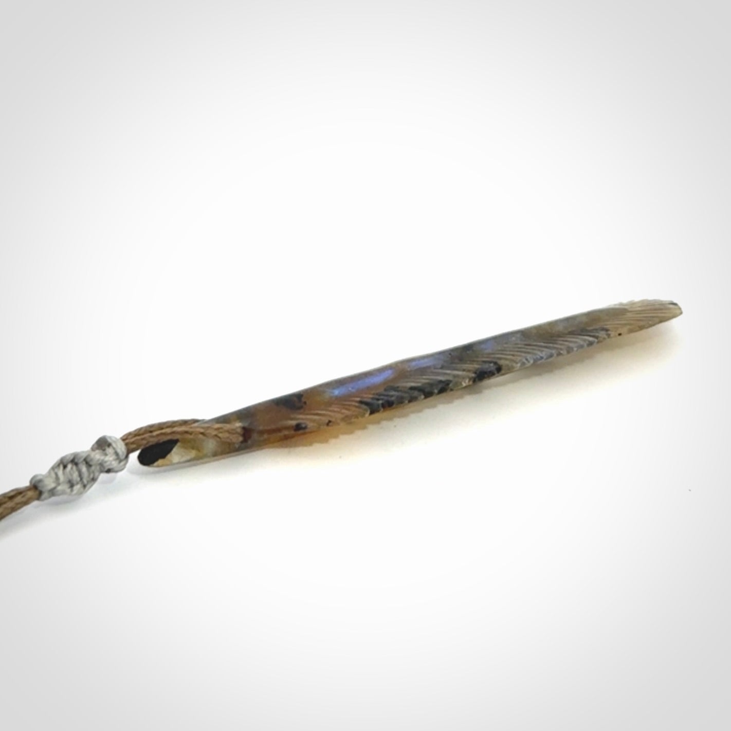 This is a hand carved feather pendant made from Labradorite stone.